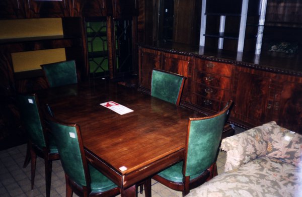 Table à manger et quatre chaises à garniture de velours vert.