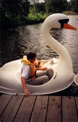 Bateau imitant un cygne avec un passager vêtu d’un gilet de sauvetage.