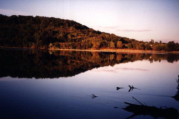 Étendue d’eau avec à sa surface le reflet d’une colline.