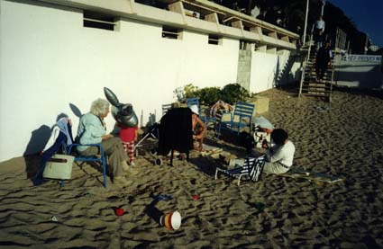 Personnes âgées assises sur des fauteuils pliants  sur une plage.
