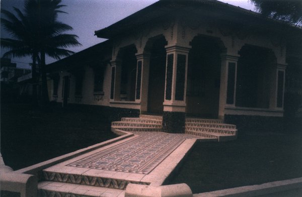 Maison mauresque et perron en céramique et palmiers.