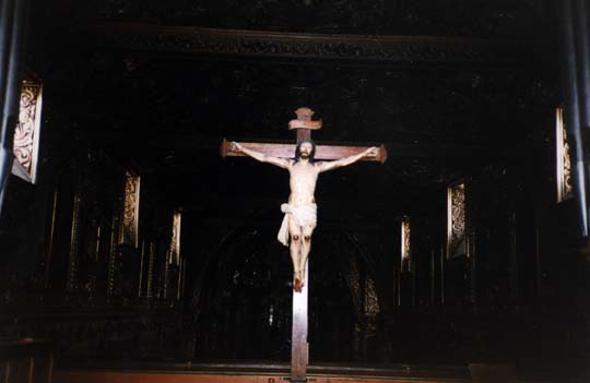 Grand Christ crucifié en bois dressé dans la nef d’une église.