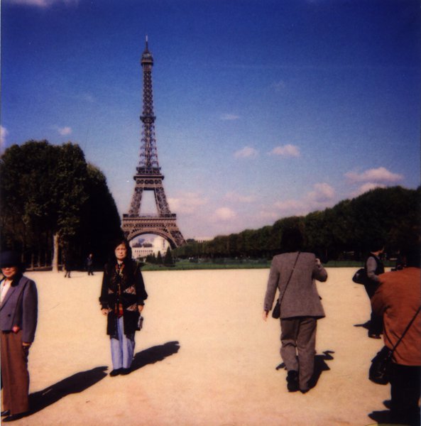 Femme brune sur l’esplanade des Invalides devant la Tour Eiffel.