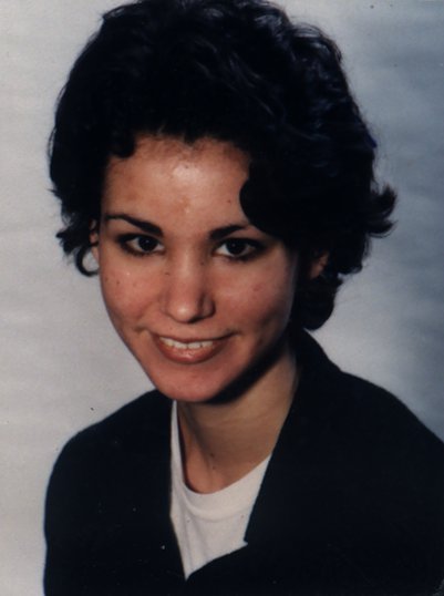 Visage de femme brune souriante.