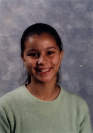 Visage de jeune fille souriante à cheveux tirés.