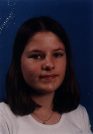Visage de fille jeune à cheveux mi-longs bruns.