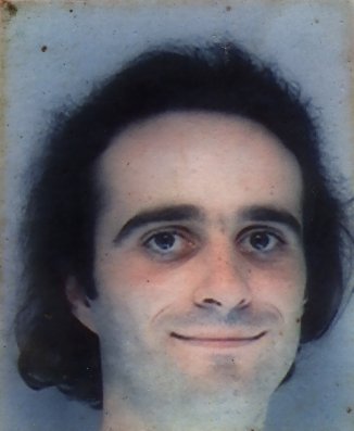Visage d’homme brun souriant.