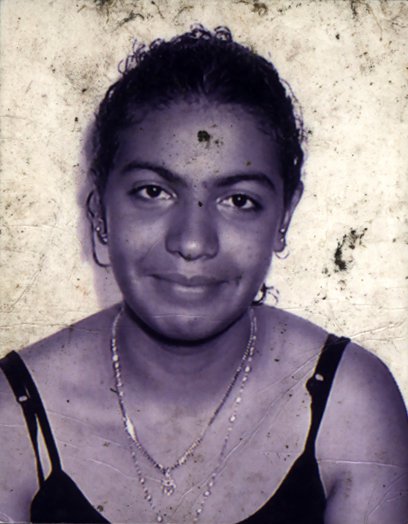 Visage de femme souriante avec un grain de beauté sur le front. Noir et blanc.