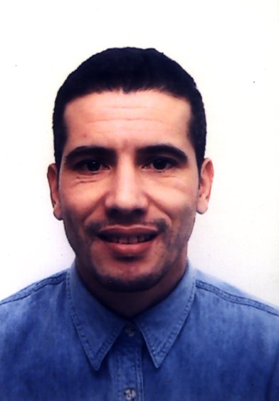 Homme souriant en chemise bleue.