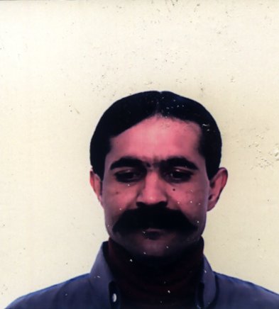 Homme yeux baissés de face avec moustache noire.