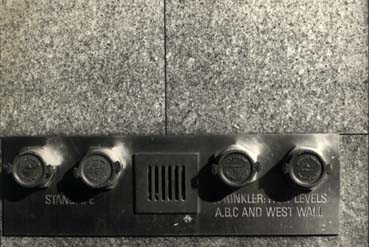 Interphone à boutons sur un mur en granit. Noir et blanc.