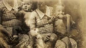 Femme corpulente en robe à carreaux avec un enfant en slip sur les genoux. Noir et blanc.