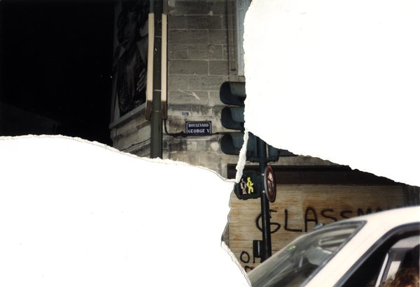 Rue de nuit avec feu de circulation et plaque « Boulevard George V ». Image avec déchirure, reconstituée.ᴬᴵ