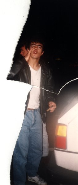 Jeune homme en blouson de cuir près d'une voiture la nuit. Image avec déchirure, reconstituée.ᴬᴵ