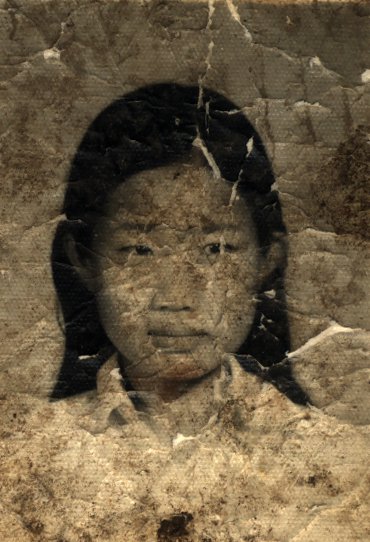 Visage de petite fille en chemise blanche. Image très abîmée. Noir et blanc.