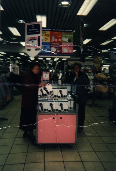 Deux femmes devant un présentoir de promotion en supermarché. Image avec déchirure, reconstituée.ᴬᴵ