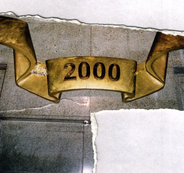 Plaque dorée « 2000 » sur un mur en marbre. Image avec déchirure, reconstituée.ᴬᴵ