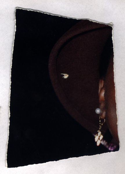 Close-up of a brown hat and a piece of jewelry. Torn fragment.ᴬᴵ