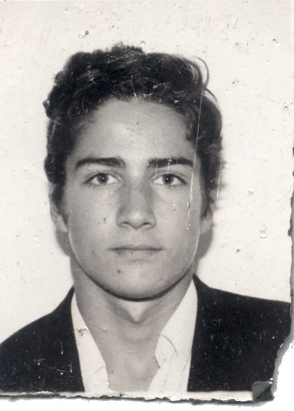 Visage de jeune homme brun à chemise et veste noire. Noir et blanc. Image avec déchirure sur le bord.