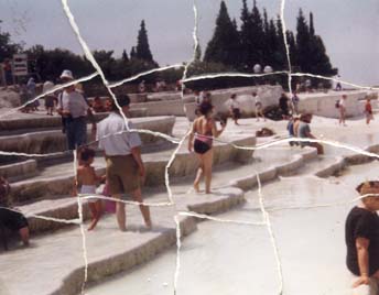 Hommes, femmes, enfants les pieds dans l’eau d’une cascade artificielle. Image déchirée reconstituée.