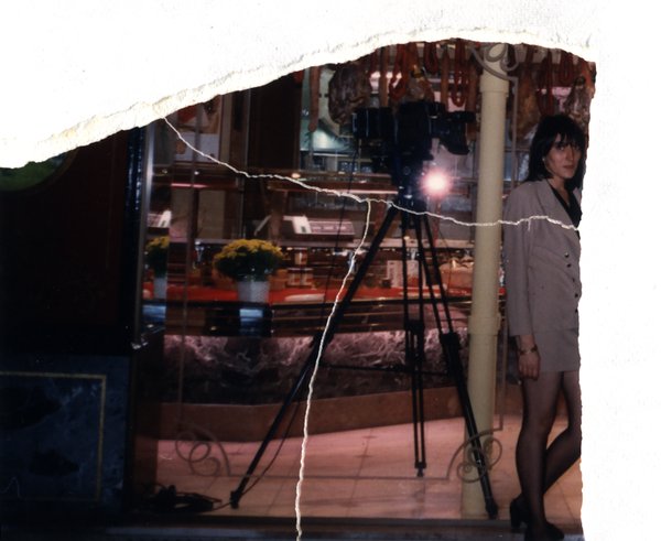 Femme debout près d'un appareil photo sur trépied dans un magasin. Image avec déchirure, reconstituée.ᴬᴵ
