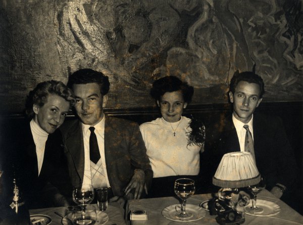 Deux couples attablés dans un restaurant. Noir et blanc.ᴬᴵ