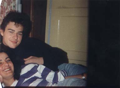 Un jeune homme brun avec une jeune femme souriante allongée à ses côtés. Image avec amorce.