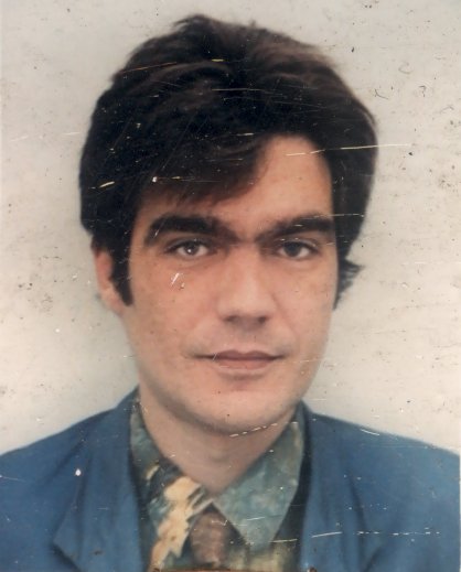 Visage d’homme brun avec costume et cravate.