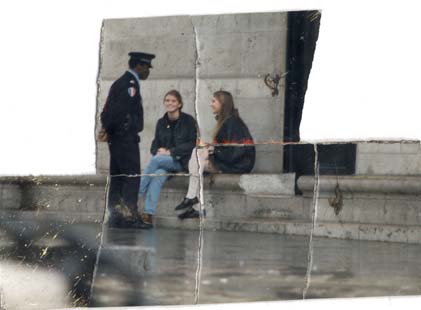 Deux jeunes filles souriantes assises dans la rue sur un parapet en marbre et un policier debout face à elles. Image déchirée.