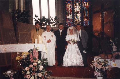Mariés et prêtre dans une église.