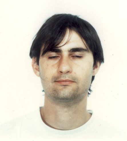 Jeune homme brun à sweat blanc les yeux fermés.