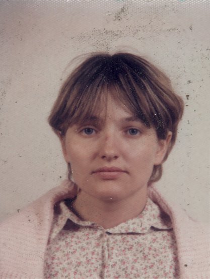 Visage de femme à cheveux courts châtain clair en chemise  et pull blanc.
