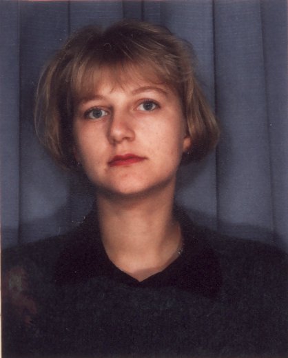 Visage de jeune femme blonde aux cheveux courts.