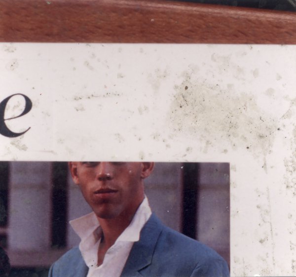 Photo collée sur un papier blanc avec la moitié d’un visage d’homme.