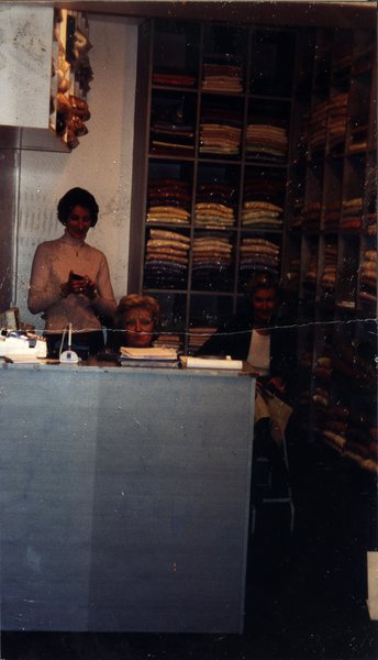Deux femmes derrière un comptoir dans un magasin de vêtements.