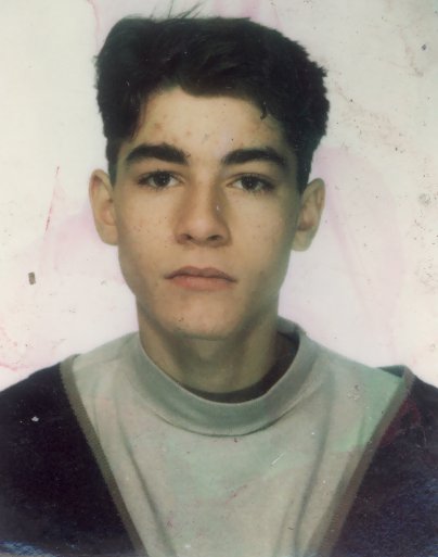 Visage de jeune homme brun à sweat gris.