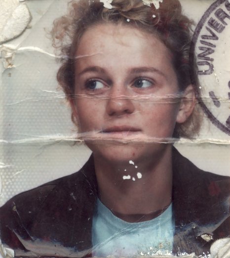 Visage de jeune fille à cheveux claire. Image avec trace de tampon bleu et pliure.