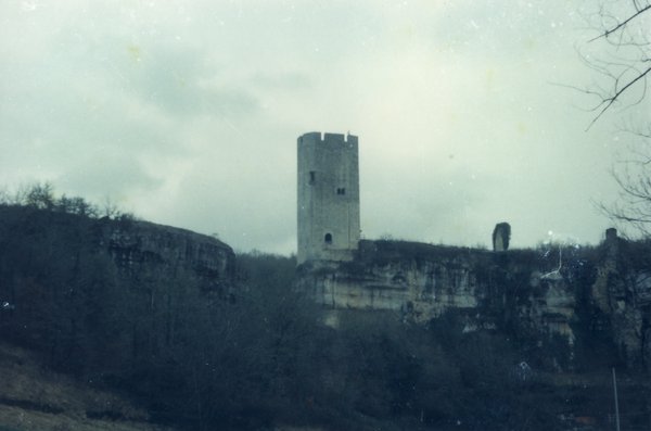 Une tour sur une colline sous un ciel nuageux.