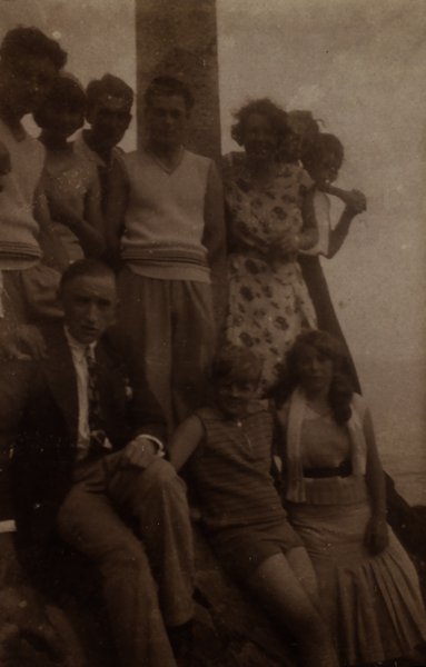 Groupe de personnes en tenue d'époque posant en extérieur. Noir et blanc.ᴬᴵ