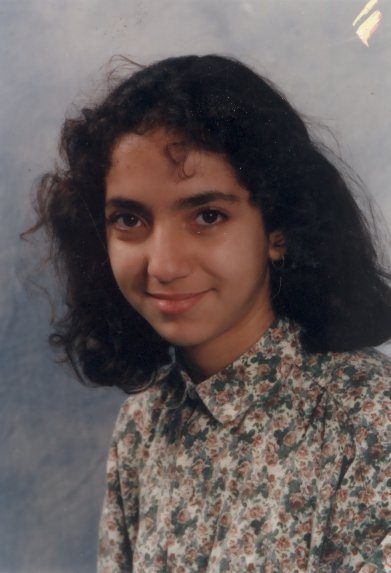 Visage de jeune fille brune souriante.