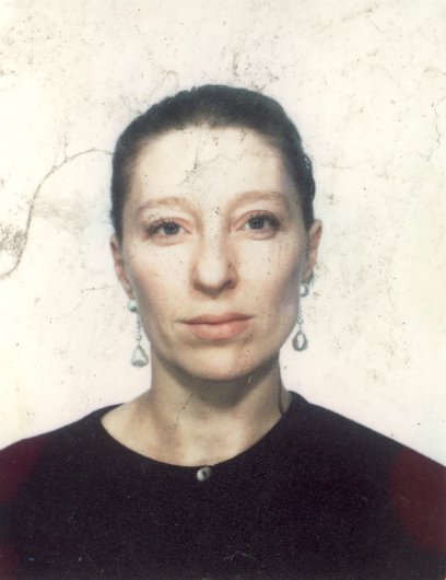 Visage de femme cheveux bruns tirés à pull noir.