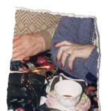 Main de femme avec ongles rouges et main d’homme devant une tasse en porcelaine à fleurs. Fragment.