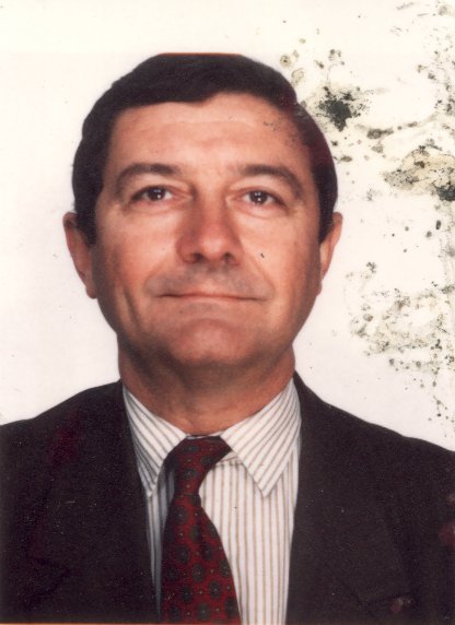 Visage d’homme brun en costume et cravate souriant. Image avec salissures.