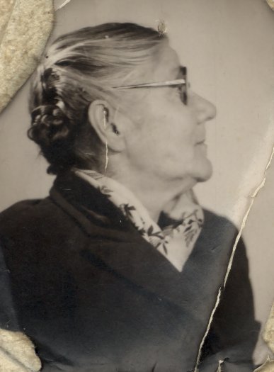 Visage de femme âgée de profil à lunettes et chignon. Noir et blanc.