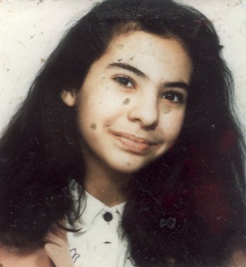 Visage de jeune fille à longs cheveux bruns. Image avec salissures.
