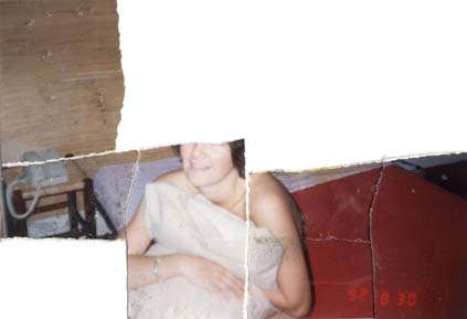 Femme brune épaules nues, un oreiller contre la poitrine. Date et  heure en impression. Image déchirée en partie reconstituée.