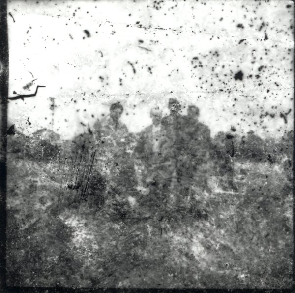 Groupe de personnes dans un champ. Fragment très abîmé. Noir et blanc.ᴬᴵ