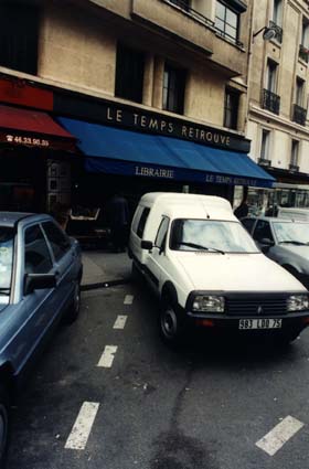Devanture de la libraire : « Le temps retrouvé » dans une rue avec voitures garées.