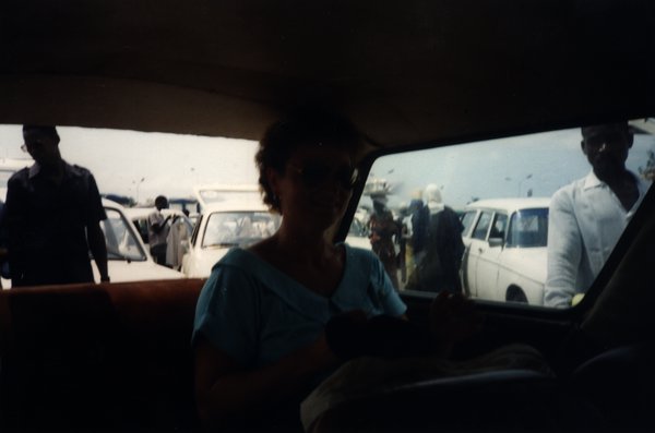 Femme à l'intérieur d'une voiture avec des passants à l'extérieur.ᴬᴵ