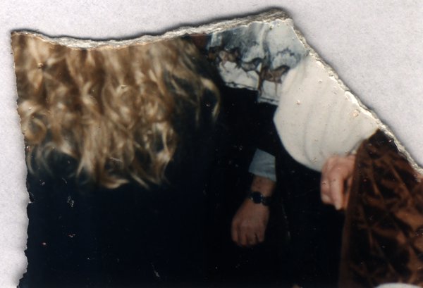 Personne aux cheveux bouclés blonds et bras avec une montre. Fragment déchiré.ᴬᴵ